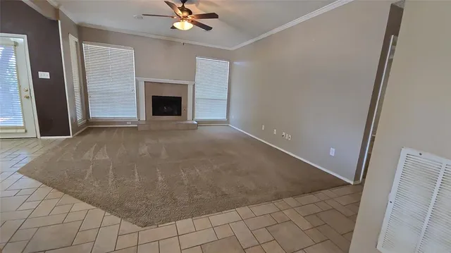 en empty room with windows and fireplace