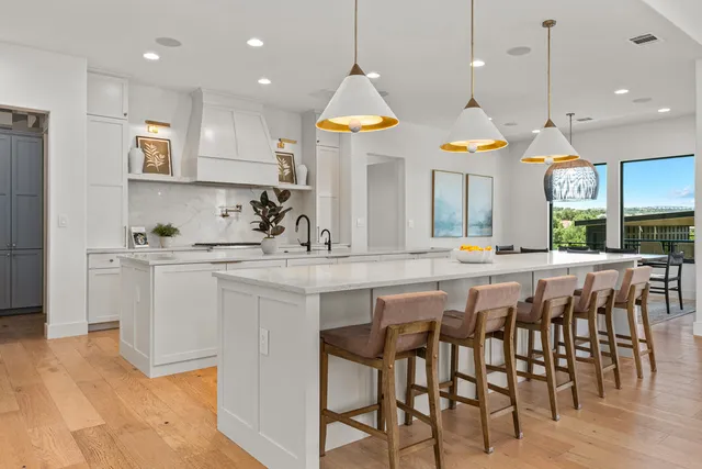 a kitchen with stainless steel appliances granite countertop a kitchen island a stove a cabinets a sink and a refrigerator