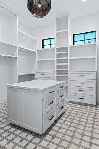 a bathroom with a granite countertop sink a mirror a window and a shower