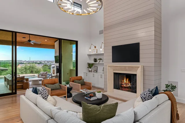 a living room with furniture a fireplace and a large window