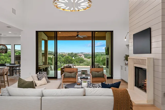 a living room with fireplace furniture and a large window