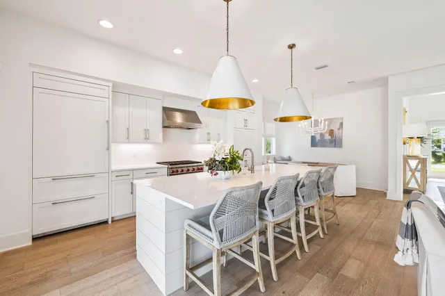 a kitchen with stainless steel appliances kitchen island wooden floors and white cabinets