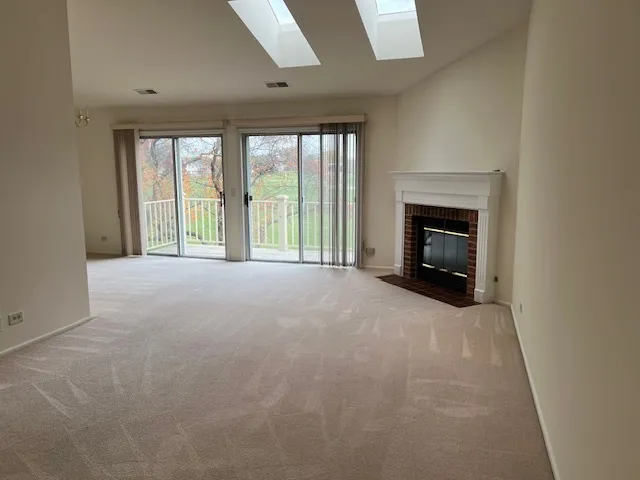 a view of an empty room with a fireplace and a window
