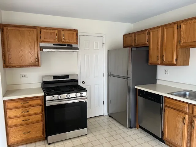 a kitchen with stainless steel appliances a stove microwave and refrigerator