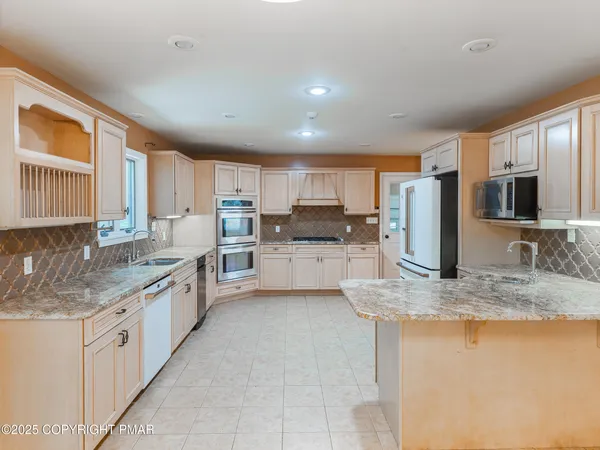 a kitchen with granite countertop white cabinets and white stainless steel appliances