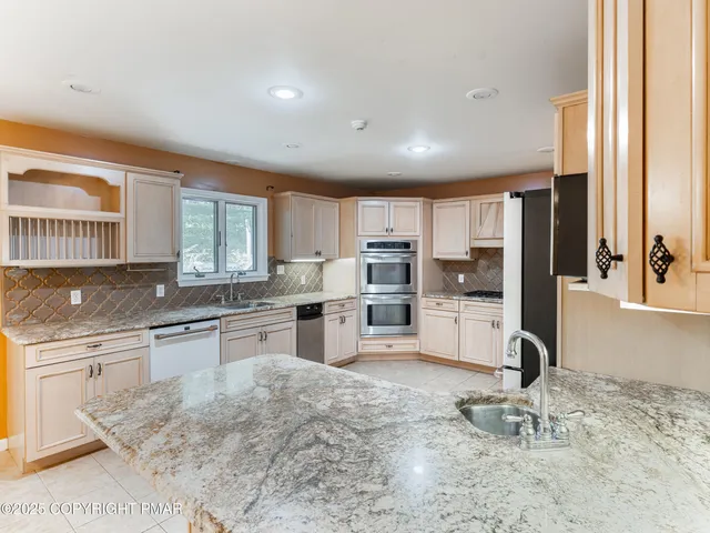 a kitchen with granite countertop a sink window and cabinets