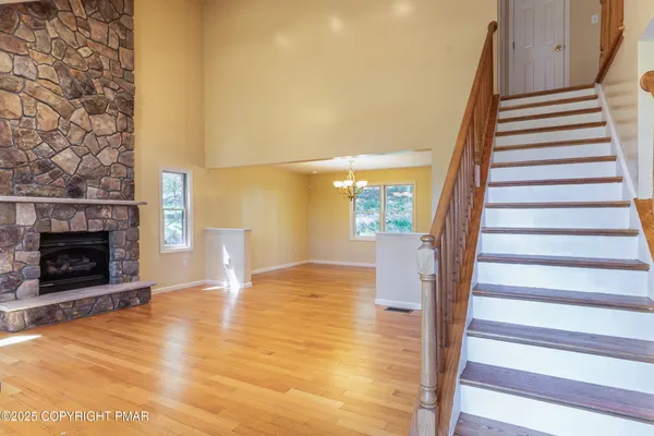 a view of an empty room with stairs and a fireplace
