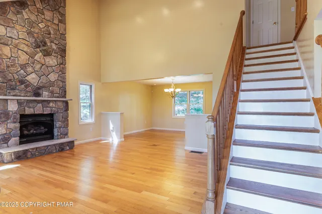 a view of an empty room with stairs and a fireplace