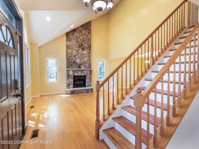 a view of an entryway wooden floor and chandelier