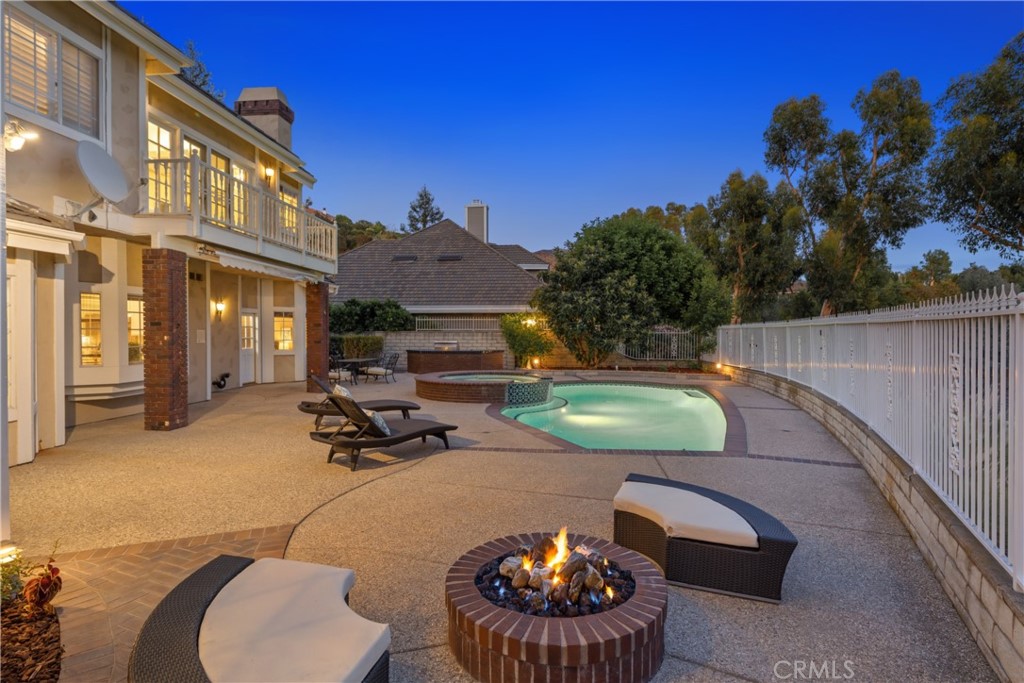 102 Mill Run Monrovia, CA 91016 - Photo 55 of 75 a view of a patio with couches table and chairs under an umbrella with wooden fence