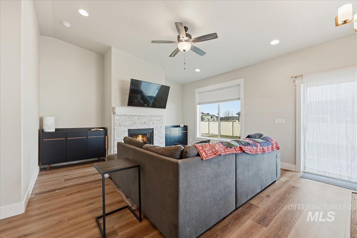 305 Tiffany Rose Way Wilder, ID 83676 - Photo 13 of 31 Living area featuring a fireplace, light wood-style flooring, vaulted ceiling, a ceiling fan, and recessed lighting
