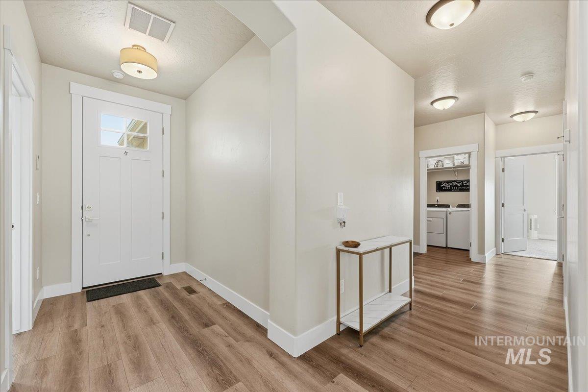 305 Tiffany Rose Way Wilder, ID 83676 - Photo 4 of 31 Entrance foyer featuring light wood finished floors, a textured ceiling, arched walkways, and washing machine and dryer