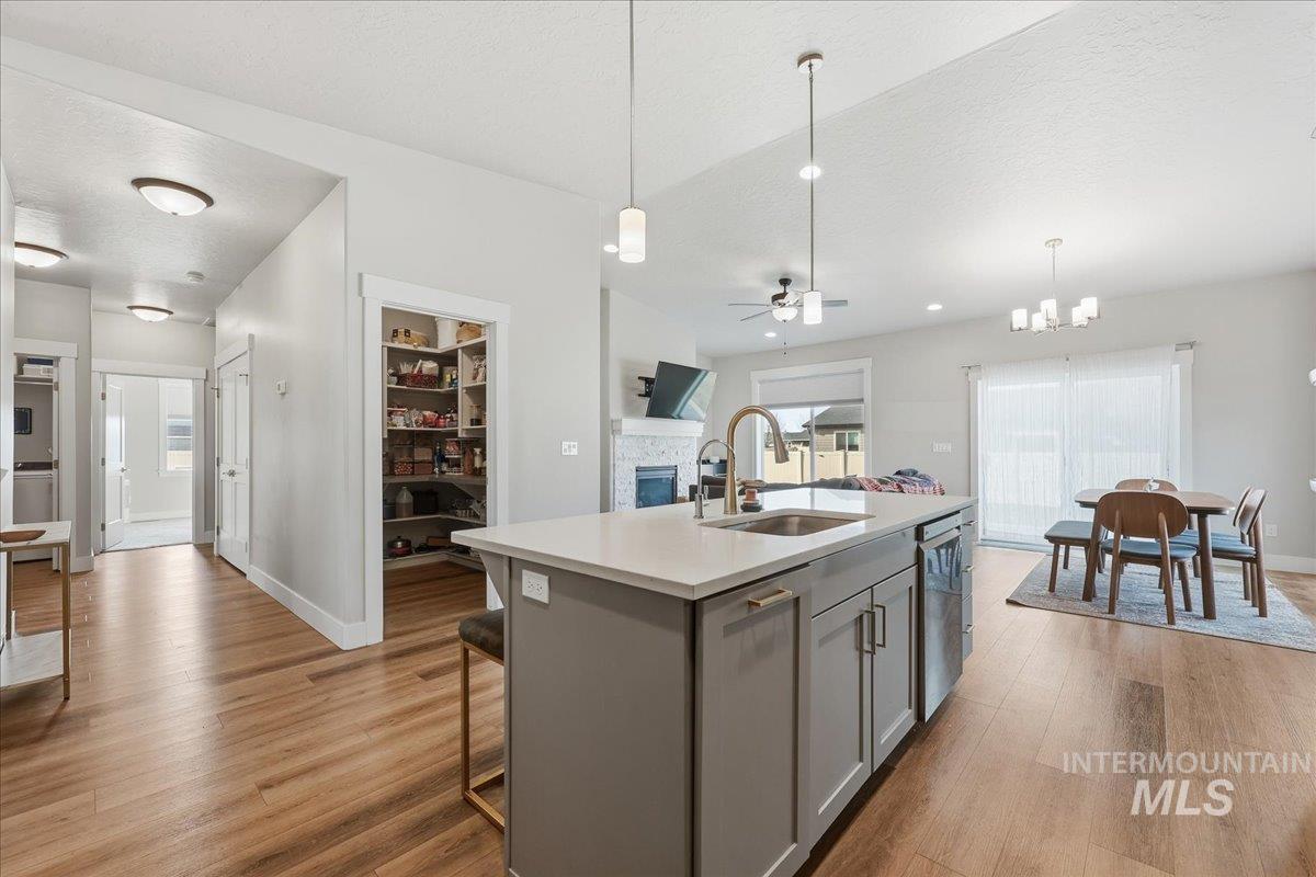 305 Tiffany Rose Way Wilder, ID 83676 - Photo 31 of 31 Kitchen with a kitchen island with sink, a textured ceiling, open floor plan, ceiling fan, and a stone fireplace