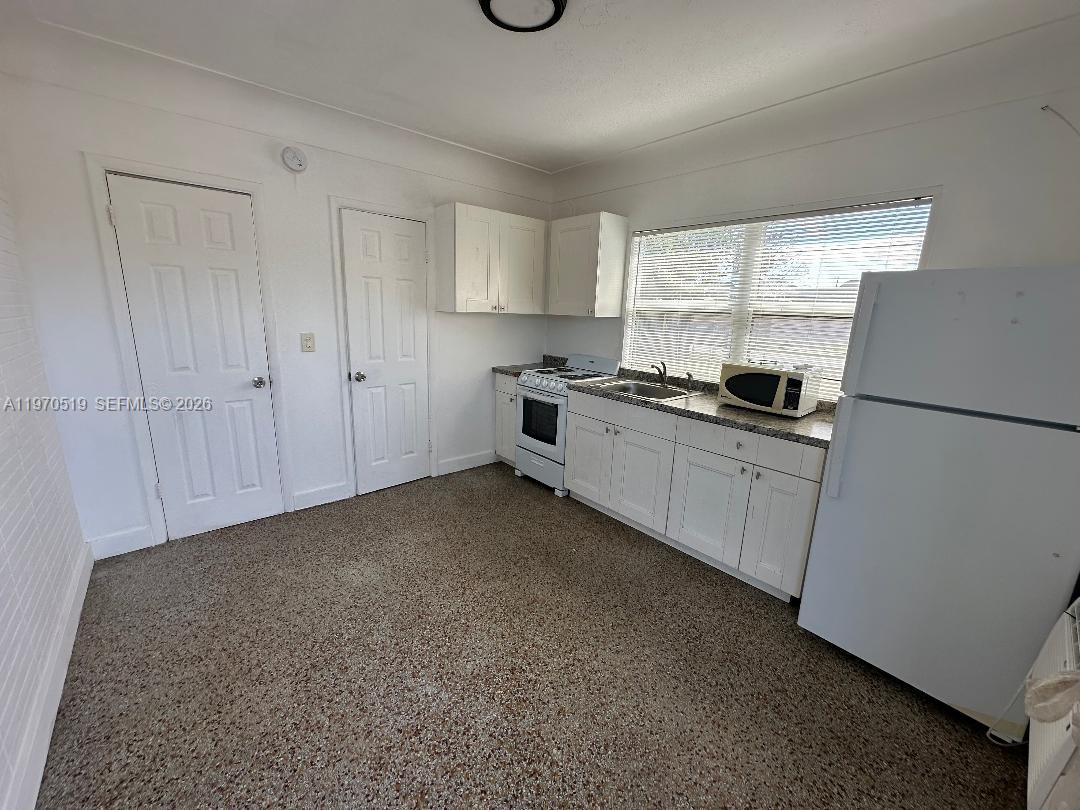 186 Northwest 1st Street, Unit 3 Homestead, FL 33030 - Photo 2 of 6 a kitchen with stainless steel appliances granite countertop a refrigerator a sink a stove a microwave a counter top and cabinets