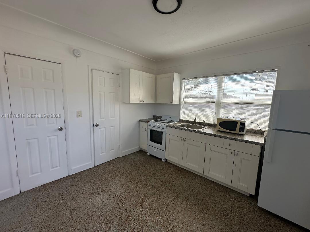 186 Northwest 1st Street, Unit 3 Homestead, FL 33030 - Photo 3 of 6 a kitchen with granite countertop white cabinets and white appliances