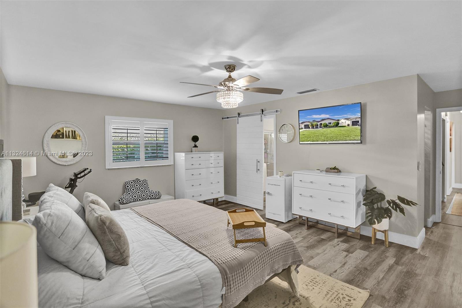 22777 Southwest 56th Avenue Boca Raton, FL 33433 - Photo 8 of 34 a bedroom with a bed and a chandelier