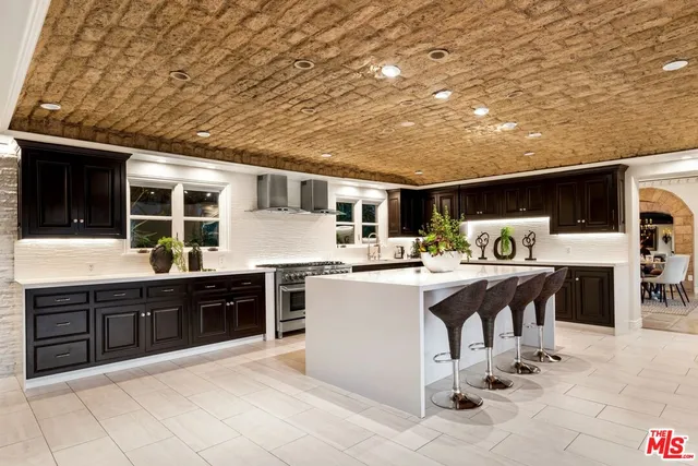 a kitchen with stainless steel appliances kitchen island granite countertop a sink and cabinets