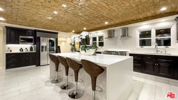 a kitchen with stainless steel appliances kitchen island granite countertop a sink and cabinets