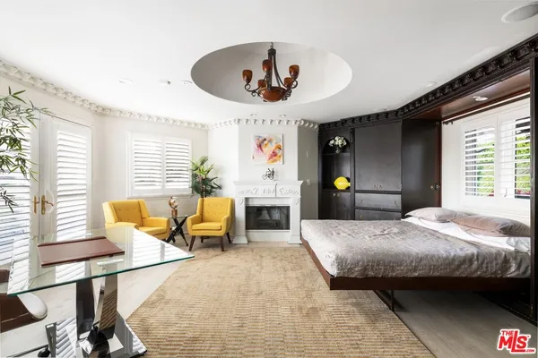 a bedroom with a bed and large windows