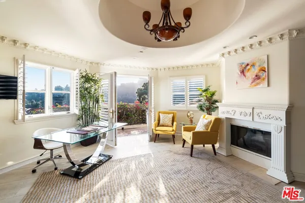 a living room with furniture a fireplace and a potted plant