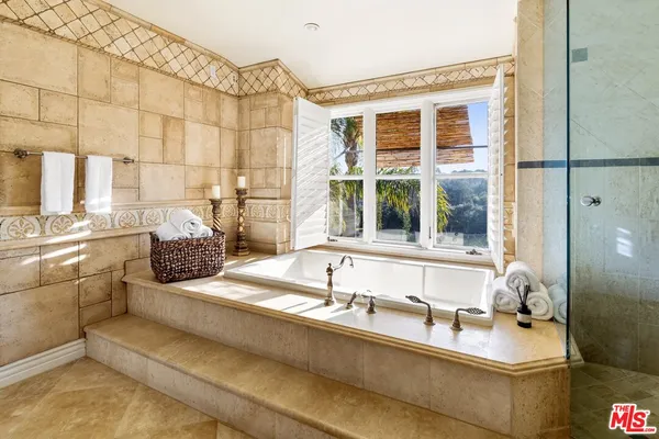 a bathroom with a granite countertop sink and a window