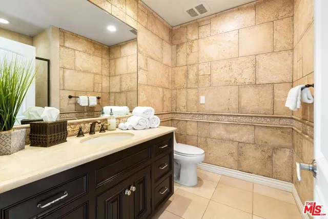 a bathroom with a sink a toilet and a mirror