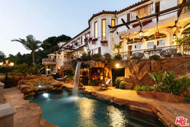 a view of a town with large trees and cars parked