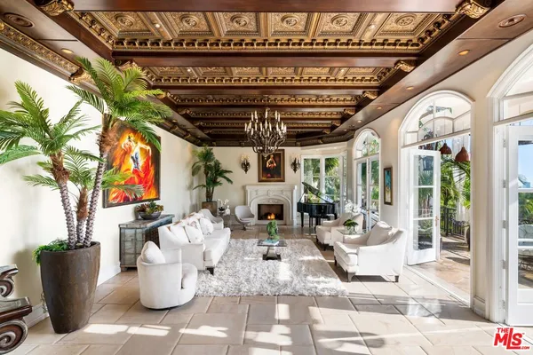 a view of a patio with table and chairs potted plants and floor to ceiling window