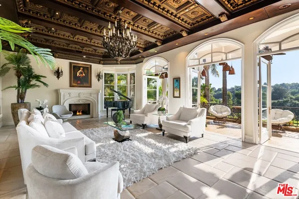 a living room with furniture a fireplace and a chandelier