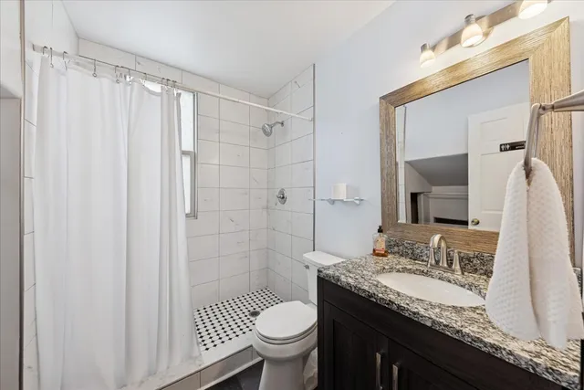 a bathroom with a granite countertop sink toilet and shower