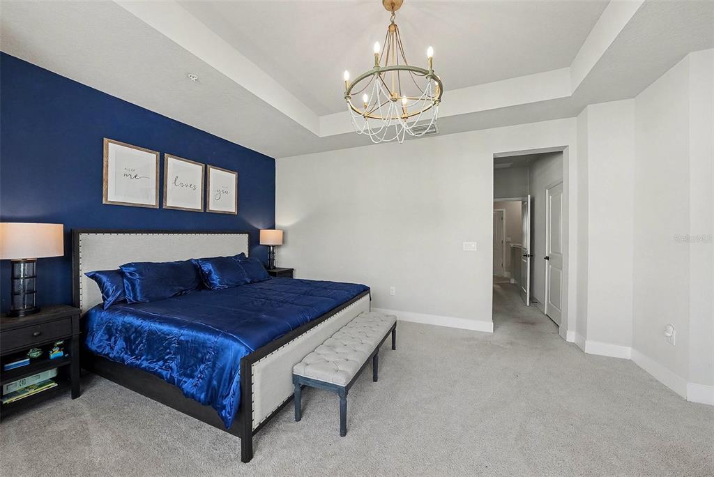 2511 North Grady Avenue, Unit 26 Tampa, FL 33607 - Photo 15 of 30 a bedroom with a bed and a chandelier