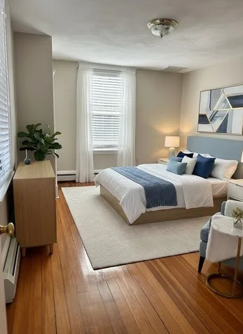 a bedroom with a bed and a potted plant