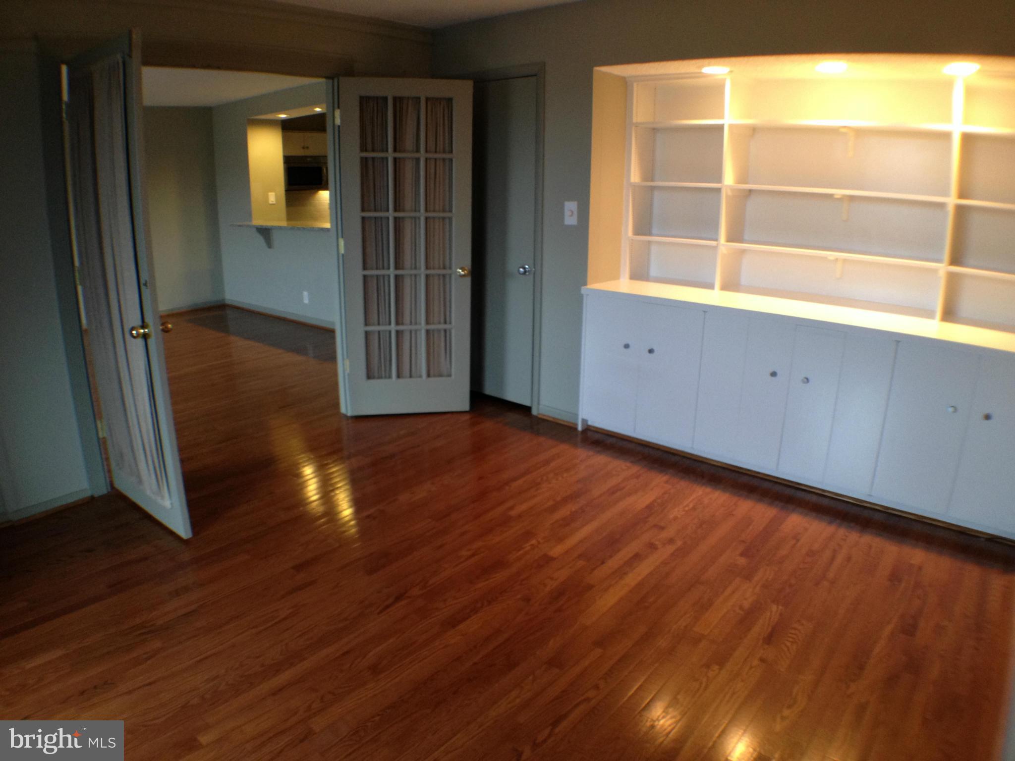 111 Hamlet Hill Road, Unit 902 Baltimore, MD 21210 - Photo 16 of 30 an empty room with wooden floor and windows