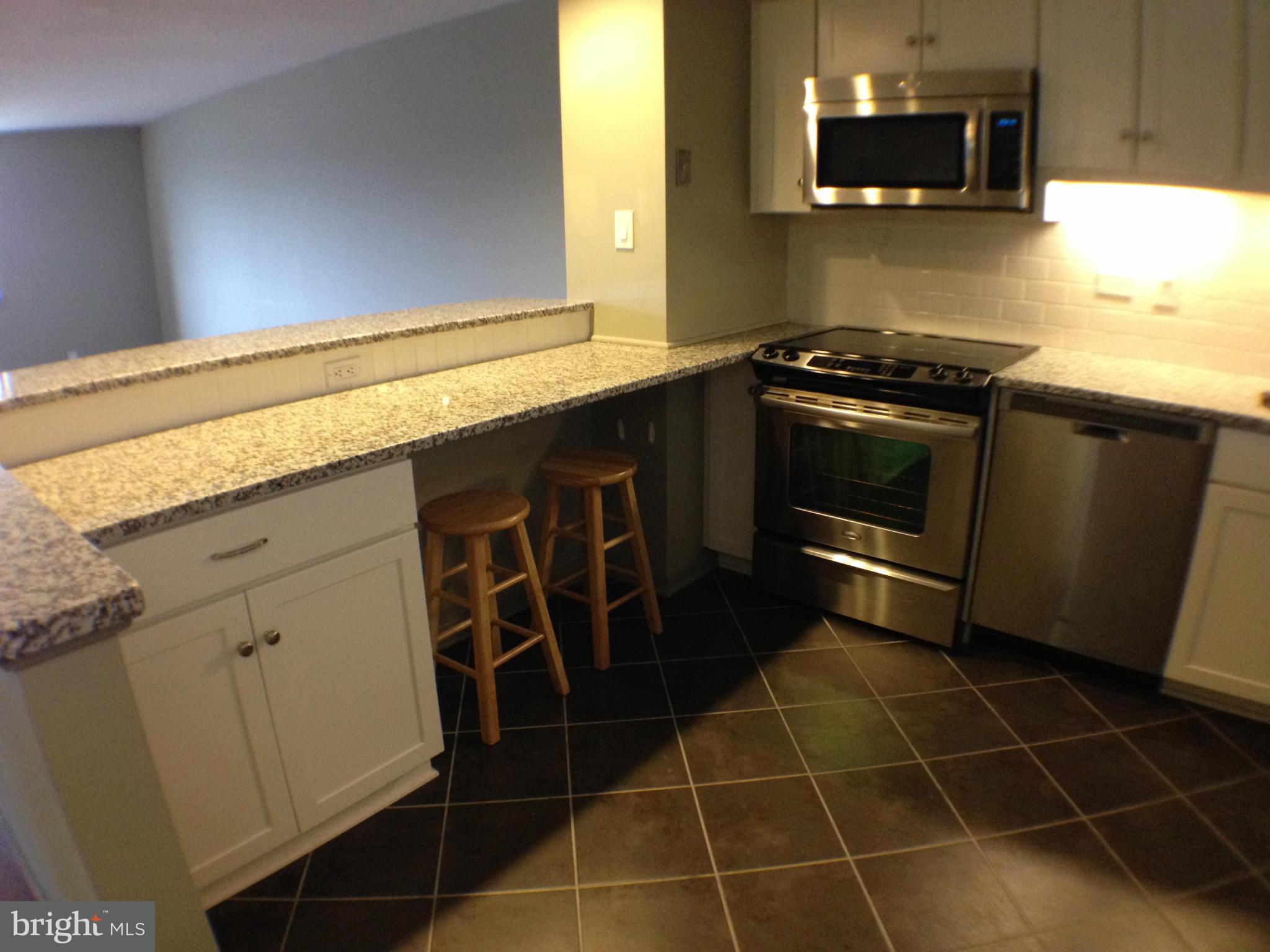 111 Hamlet Hill Road, Unit 902 Baltimore, MD 21210 - Photo 2 of 30 a kitchen with a sink a stove and microwave