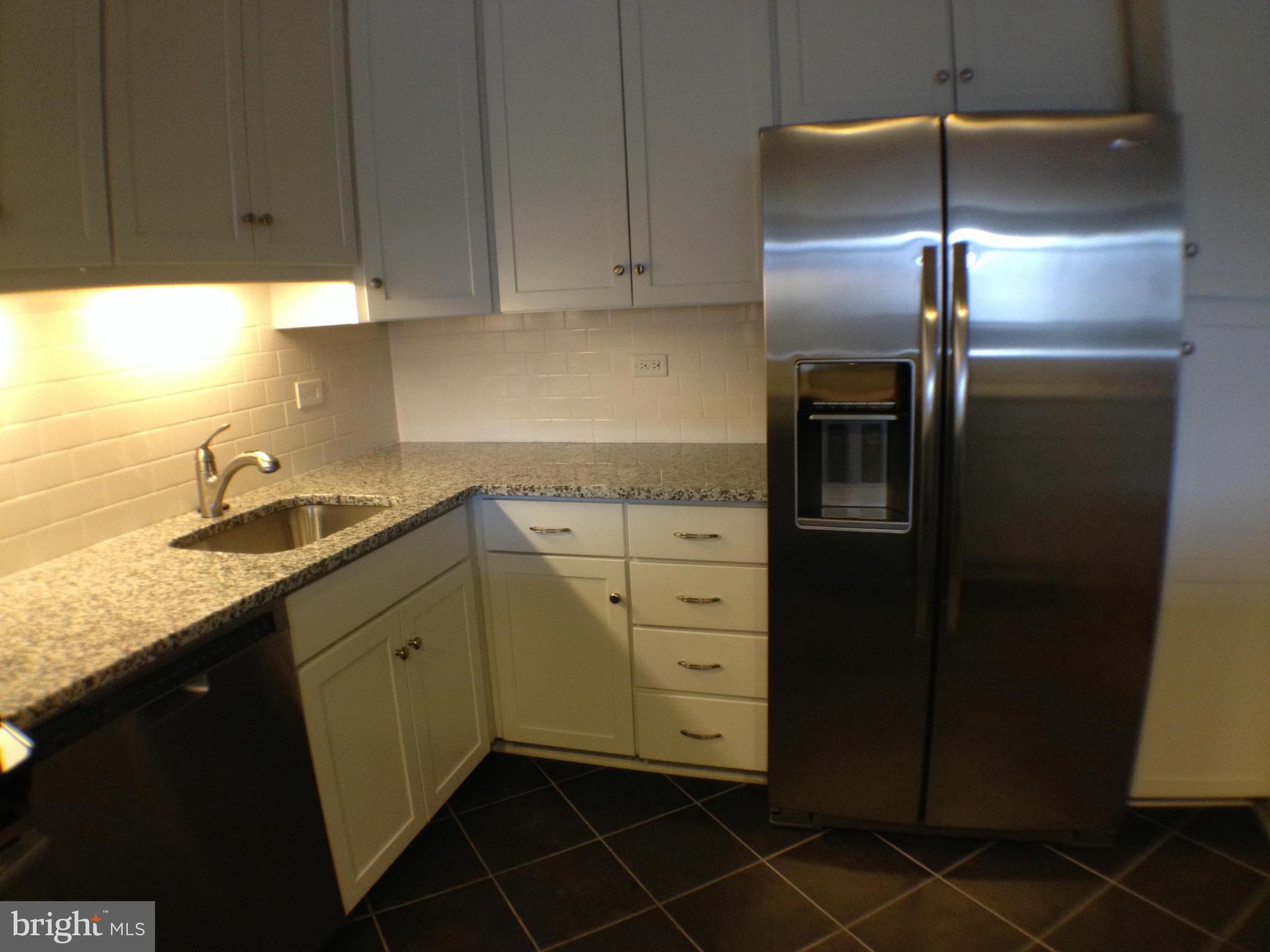 111 Hamlet Hill Road, Unit 902 Baltimore, MD 21210 - Photo 3 of 30 a kitchen with a refrigerator and cabinets