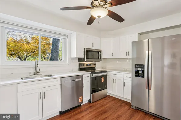 a kitchen with a sink stainless steel appliances and window