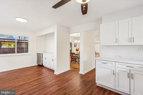 a view of a kitchen with wooden floor and electronic appliances
