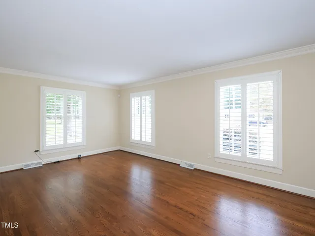 an empty room with windows and fireplace