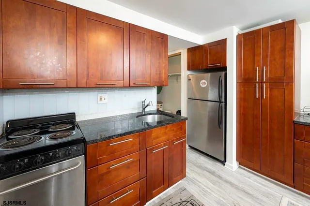a kitchen with granite countertop wooden cabinets and a stove top oven