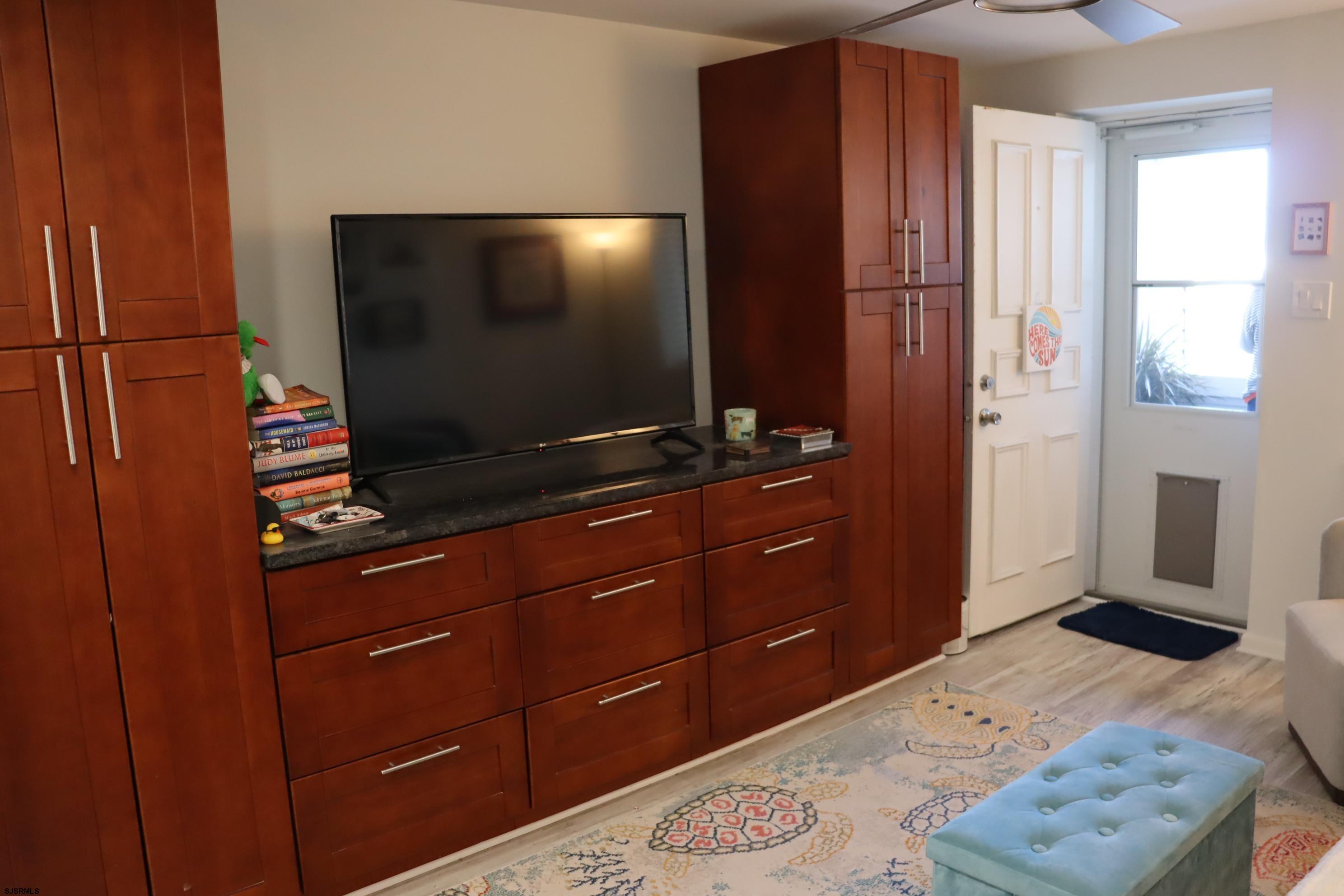 9201 Atlantic Avenue, Unit 18 Margate City, NJ 08402 - Photo 5 of 12 a room with a dresser and a flat screen tv