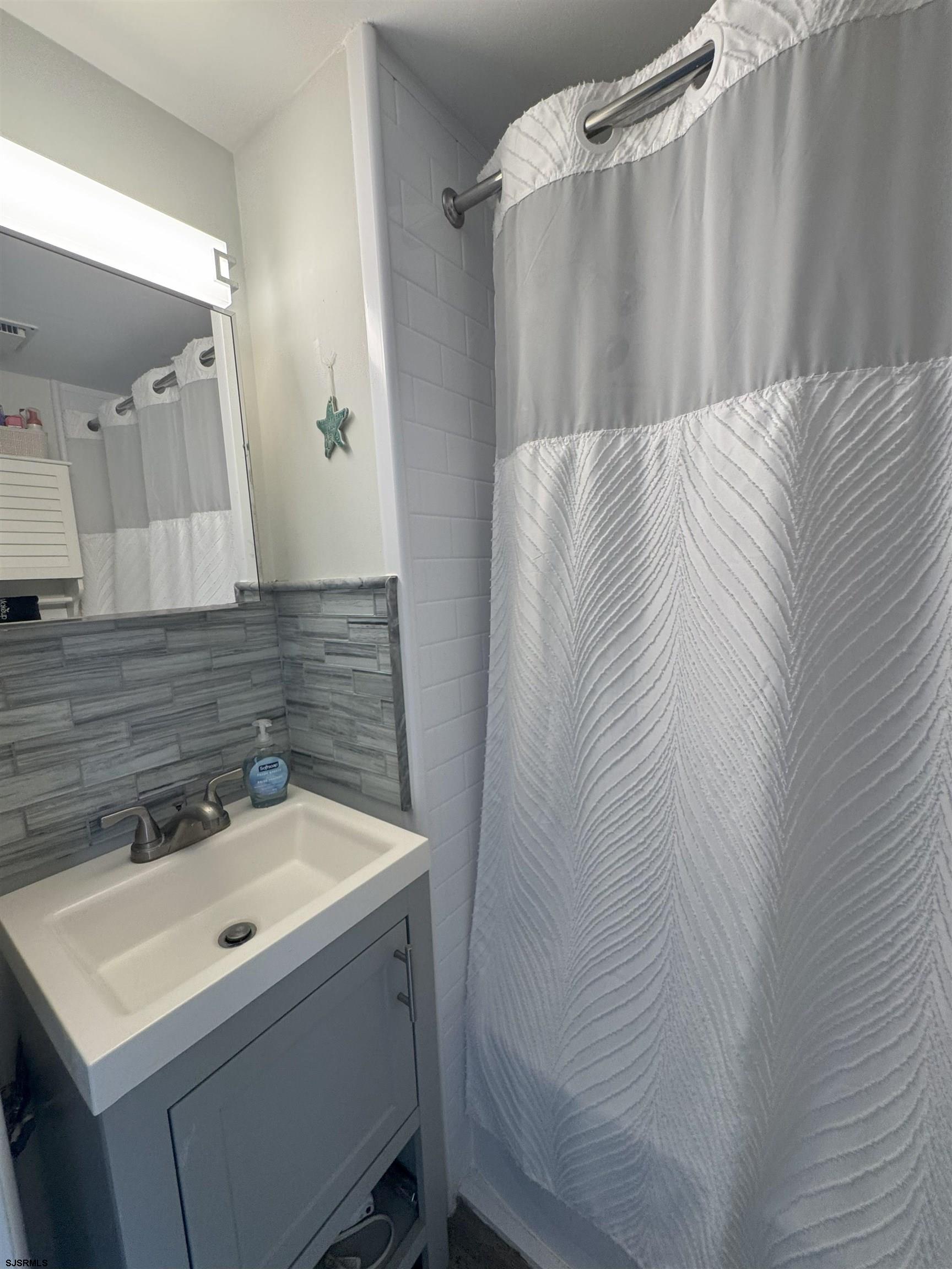9201 Atlantic Avenue, Unit 18 Margate City, NJ 08402 - Photo 7 of 12 a bathroom with a sink and a mirror
