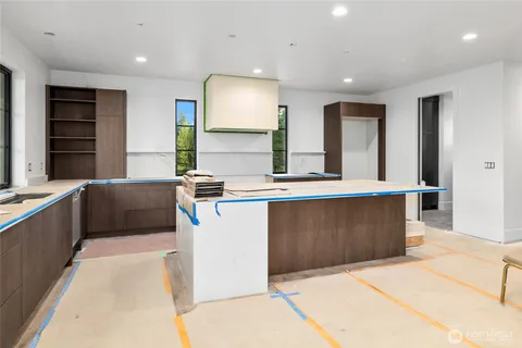 a large kitchen with kitchen island a sink a counter space and a window