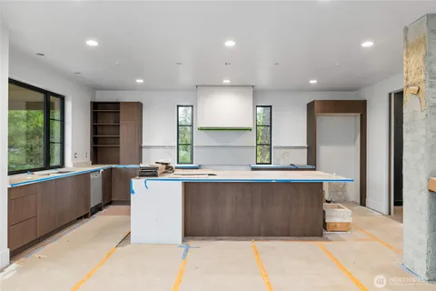 a kitchen with large windows and refrigerator