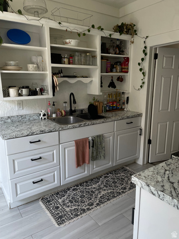 857 27th Street Ogden, UT 84403 - Photo 5 of 20 Kitchen featuring white shaker-style cabinetry, patterned stone countertops, and a dual basin sink with a matte black faucet