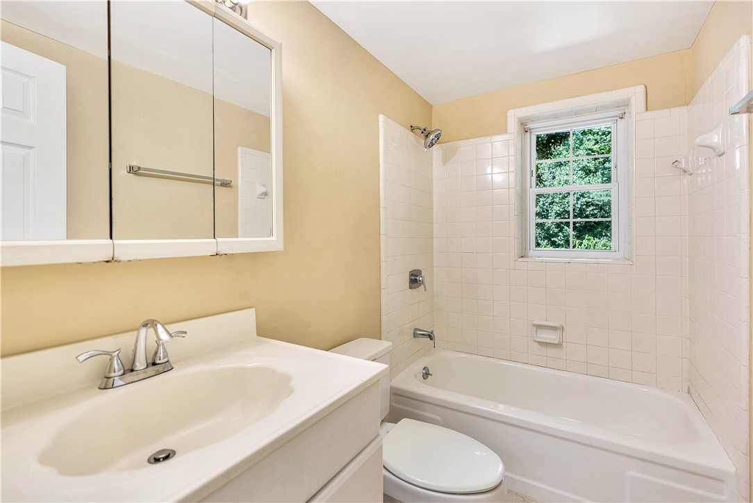 2011 Forest Drive Seneca, SC 29672 - Photo 33 of 36 A well-lit full bathroom features a window overlooking lush greenery and a classic tub-shower combination.