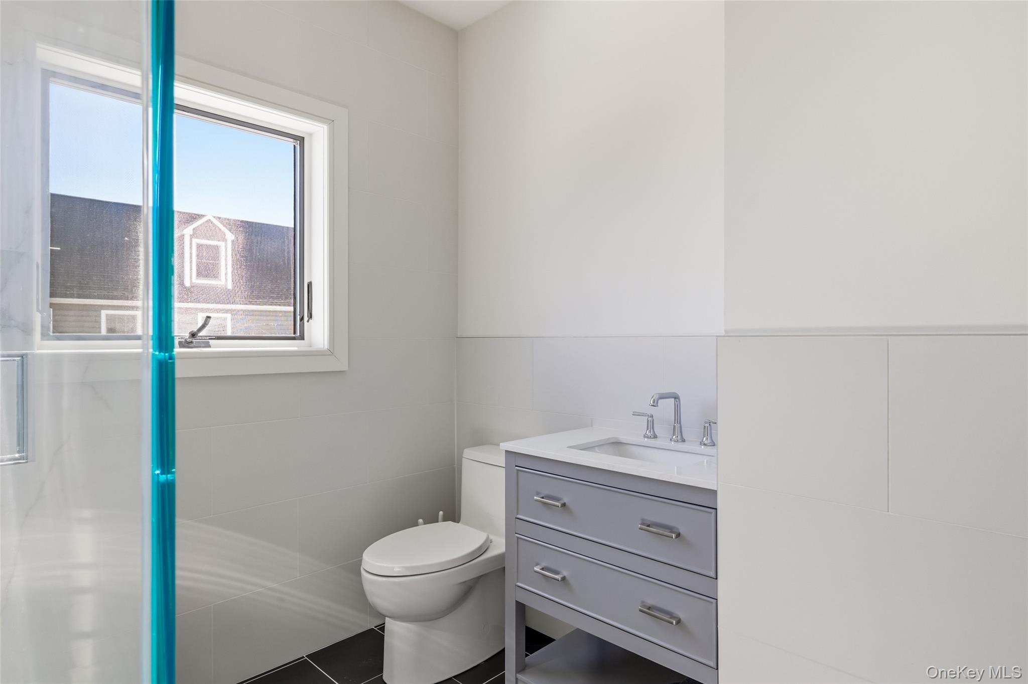 56 Suffolk Road Island Park, NY 11558 - Photo 13 of 14 a bathroom with a toilet sink vanity and mirror