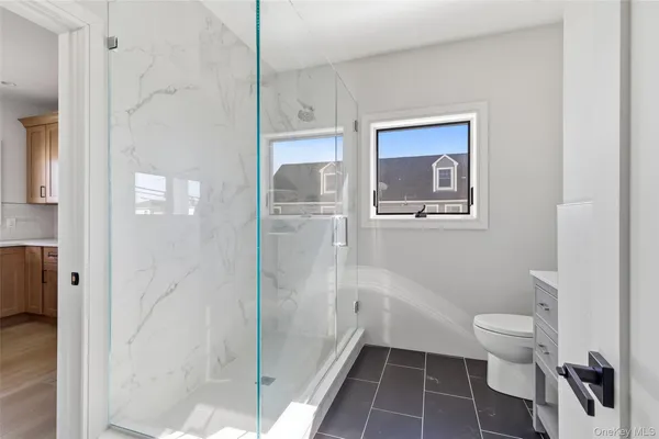 a bathroom with a toilet and a shower