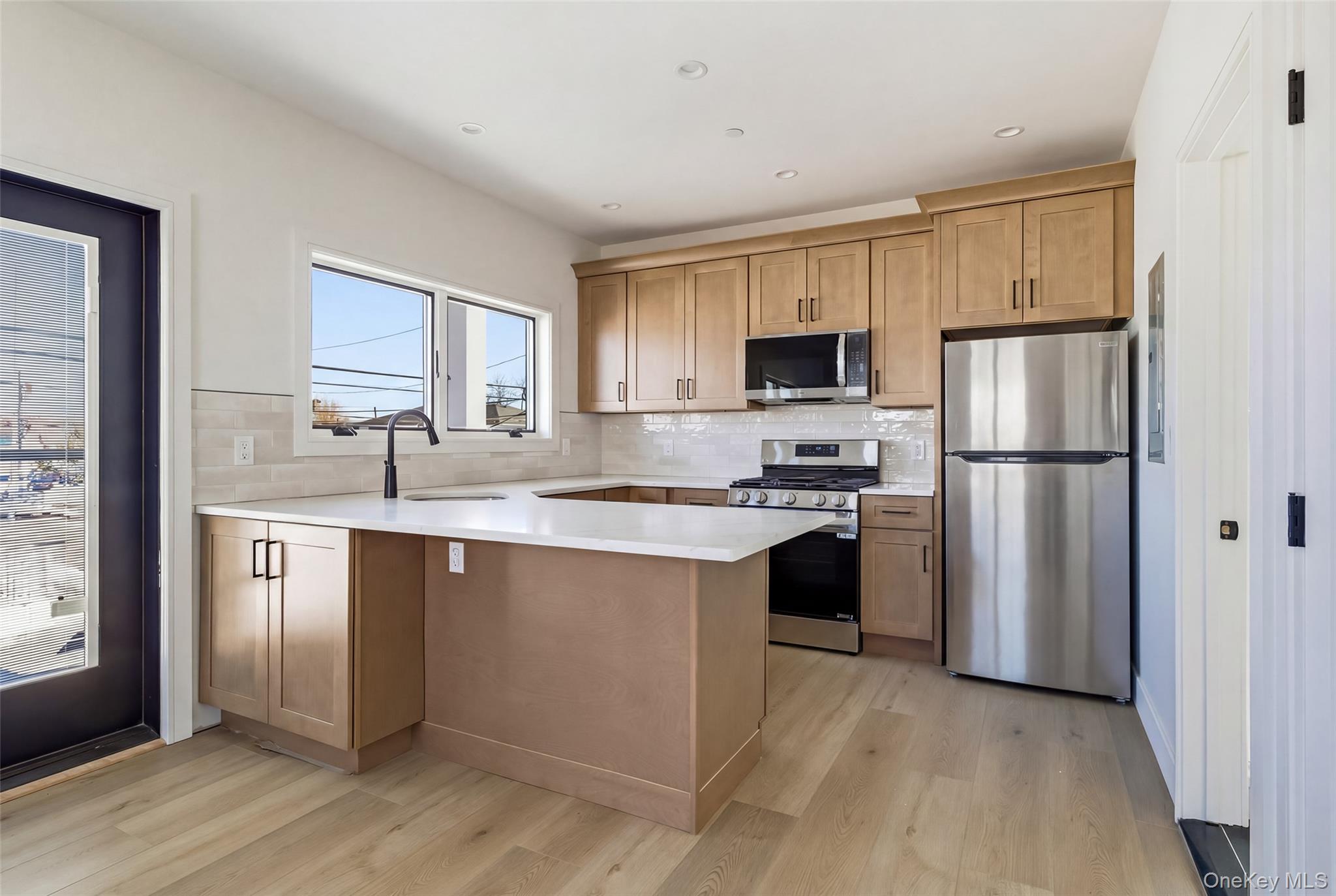 56 Suffolk Road Island Park, NY 11558 - Photo 2 of 14 a kitchen with a refrigerator sink and cabinets