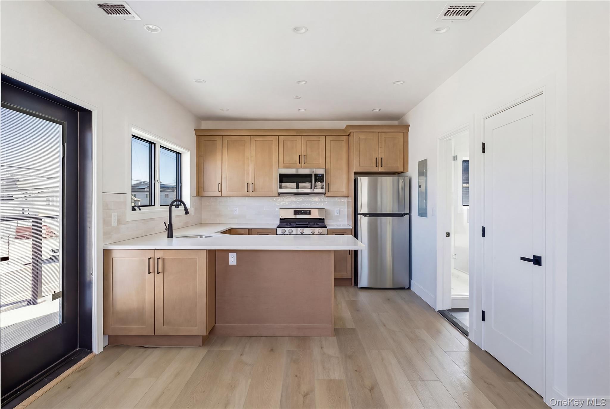 56 Suffolk Road Island Park, NY 11558 - Photo 5 of 14 a kitchen with refrigerator cabinets and wooden floor