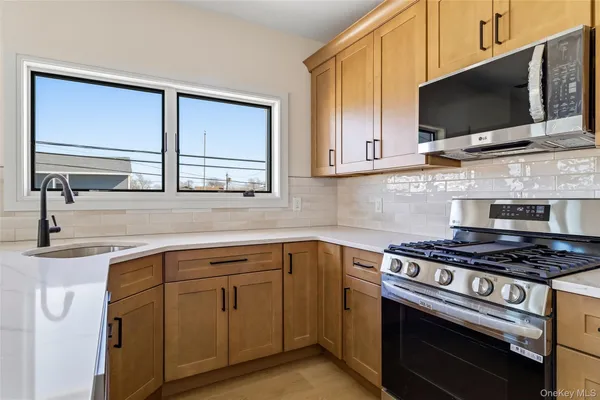 a kitchen with cabinets appliances and a window